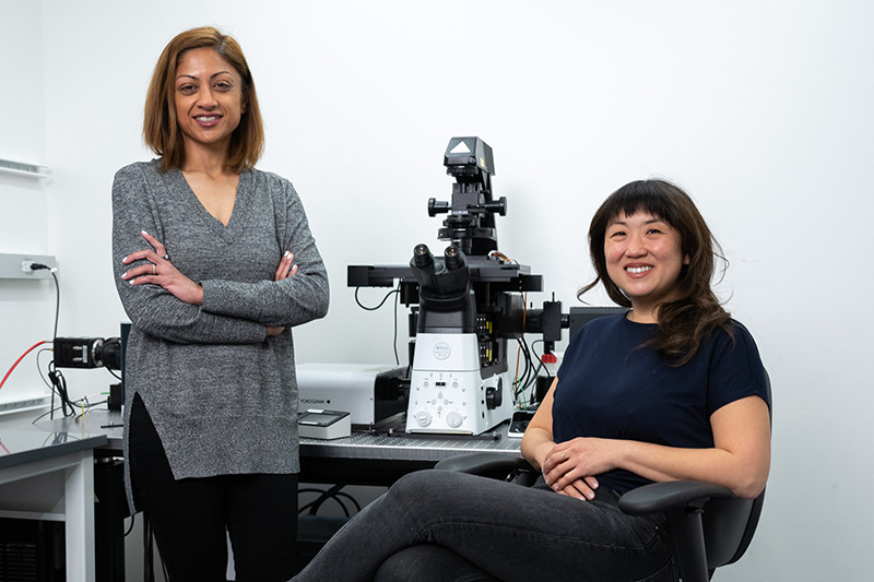 Prachee Avasthi and Seemay Chou with a microscope