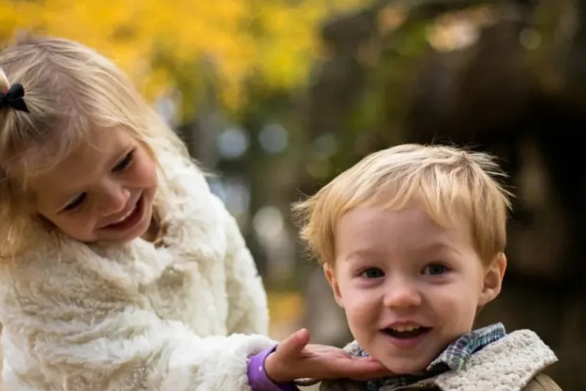 Little girl touching little boy's face